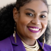 A Black Woman with black glasses sipping a coffee cup with the word DATA and a nwea pen.